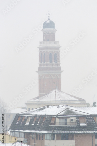Winter unusual aerial landscape of Rovigo in Veneto in the Po valley, Italy. During a snowfall the city roofs got white even the historic landmark as the Rotonda church and its bell tower photo