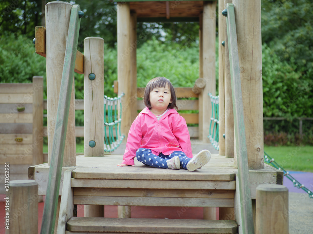 baby girl sit on the wooden deck in Summer forest park baby girl sit on the wooden deck in Summer forest park