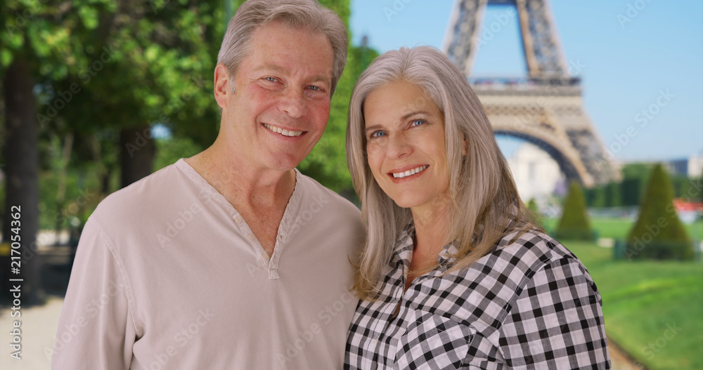 Senior Caucasian couple stand together in front of Eiffel Tower Senior Caucasian couple stand together in front of Eiffel Tower
