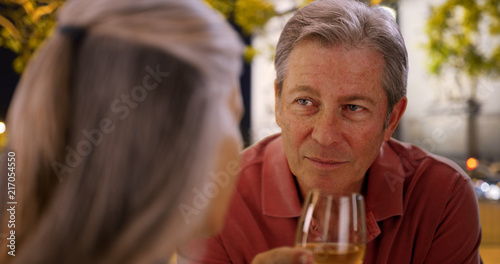 Mature Caucasian male chats with female at restaurant over wine