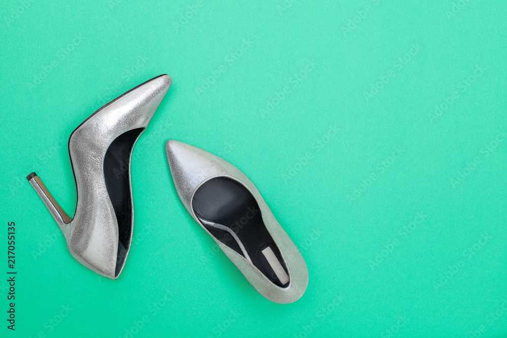 Fashion blog concept. bright silver women high heel shoes on mint green background. Flat lay, top view trendy beauty female background. Fashion blog concept. bright silver women high heel shoes on mint green background. Flat lay, top view trendy beauty female background.