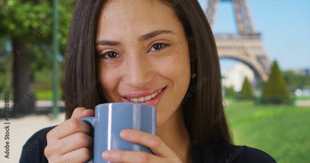 Close up of pretty Latin female drinking coffee near Eiffel Tower Close up of pretty Latin female drinking coffee near Eiffel Tower