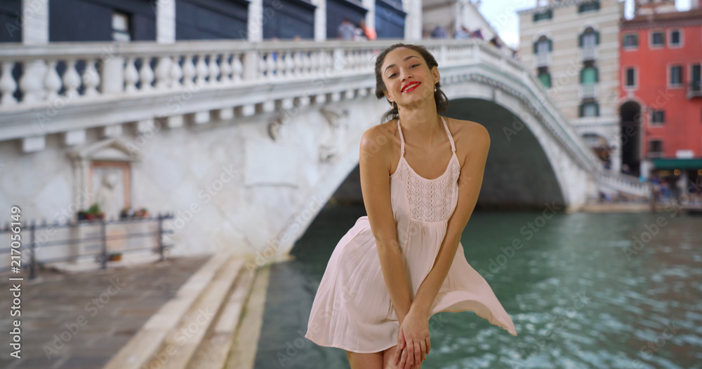 Sexy Latina female pushing dress down in the wind by Grand Canal Italy  Stock Photo | Adobe Stock