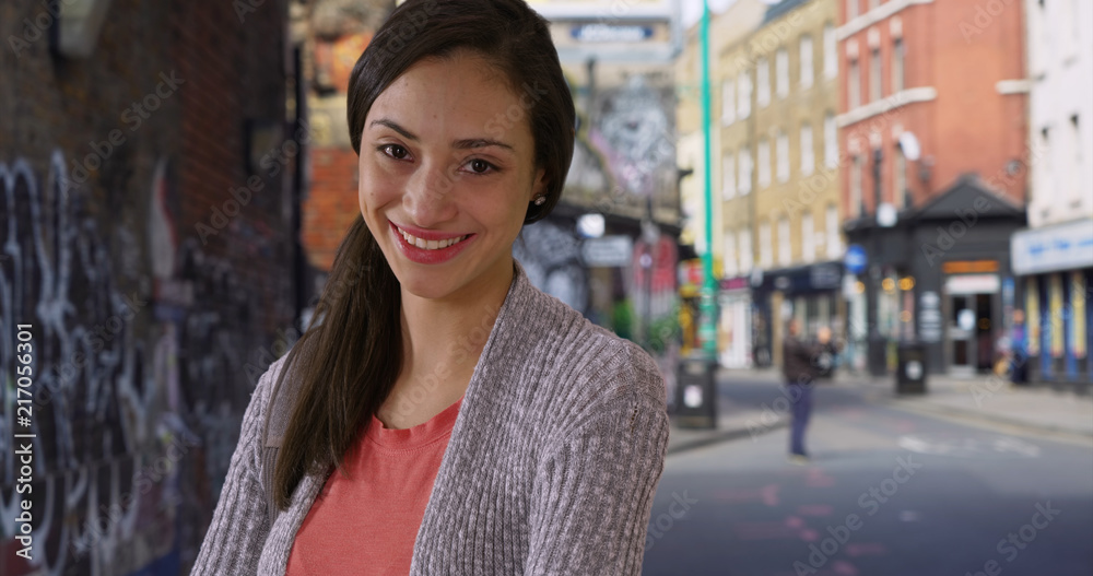 Fototapeta premium Casual portrait of happy smiling Latina woman on urban street in London UK