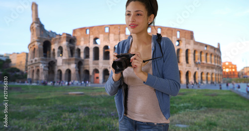 Cute Latina tourist sightseeing in Rome takes picture near Roman coliseum © rocketclips