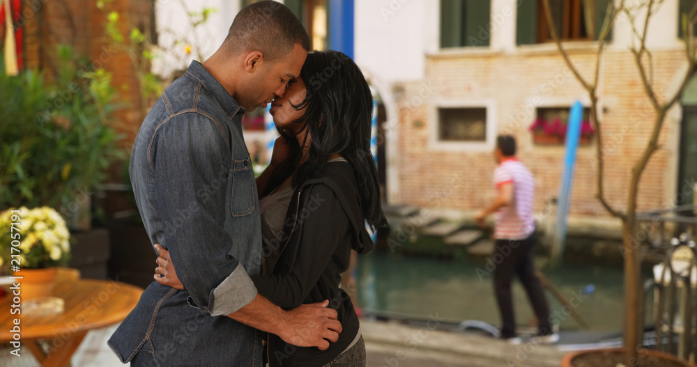 African boyfriend and girlfriend kiss passionately in Venice Italy