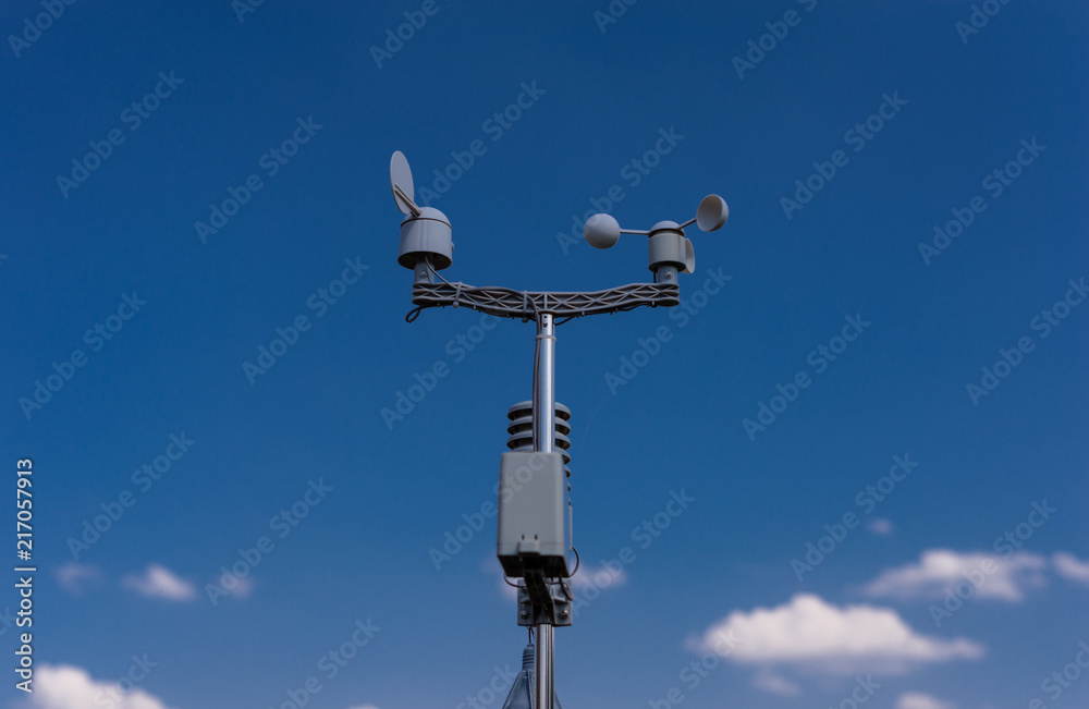 Home weather station on a background of blue sky with the sun behind the clouds. Measurement of temperature, humidity and wind direction Home weather station on a background of blue sky with the sun behind the clouds. Measurement of temperature, humidity and wind direction