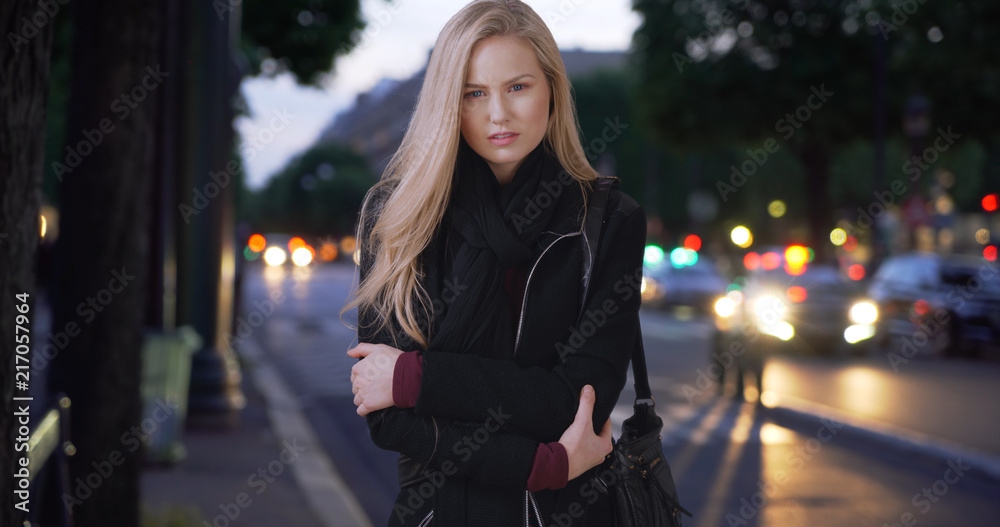 Fototapeta premium Stunning modern white woman poses for camera while standing on sidewalk