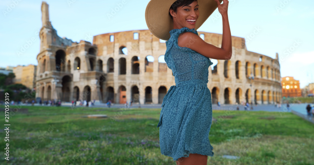 Young attractive African-American female posing happily near Roman Colosseum