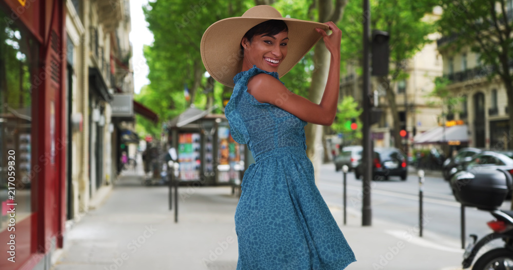 Energetic black woman enjoying herself on sidewalk in Paris France