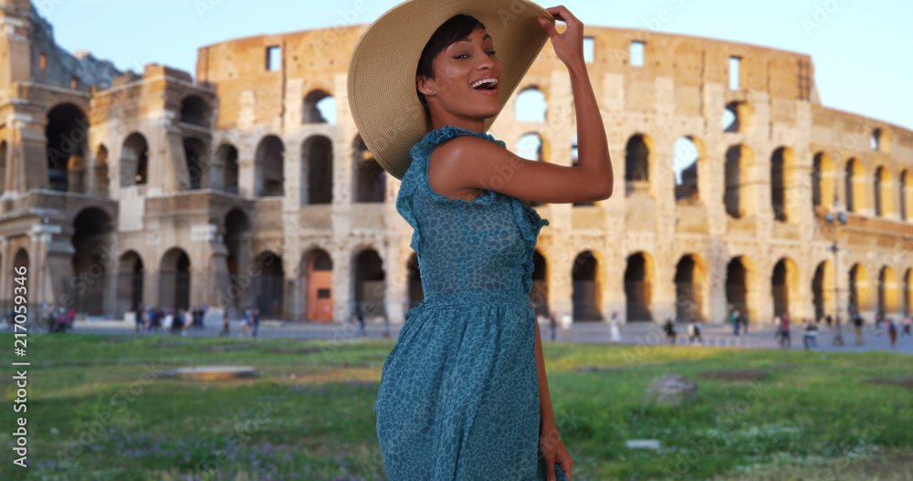 Traveling African-American woman dancing in front of Colosseum in Rome