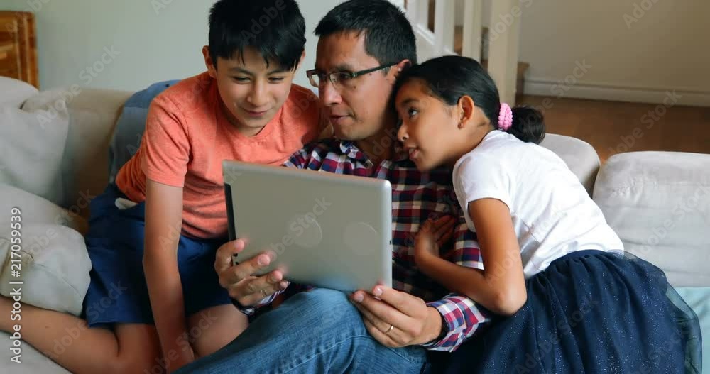 Father and kids using digital tablet in living room 4k