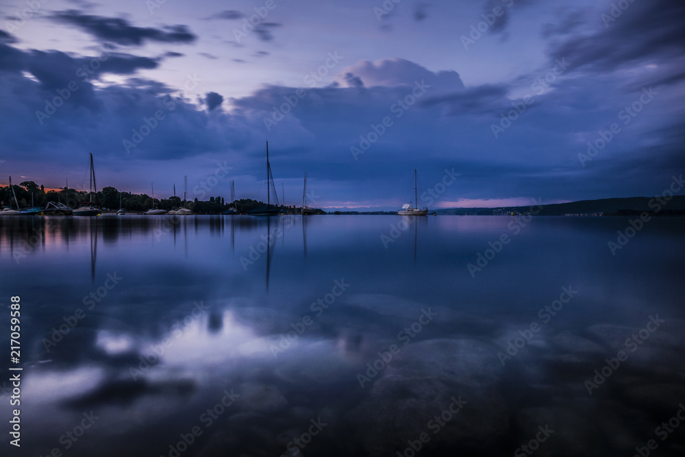 Bodensee im Sommer zur blauen Stunde mit kraftvoller Wolkenstimmung und Segelbooten 