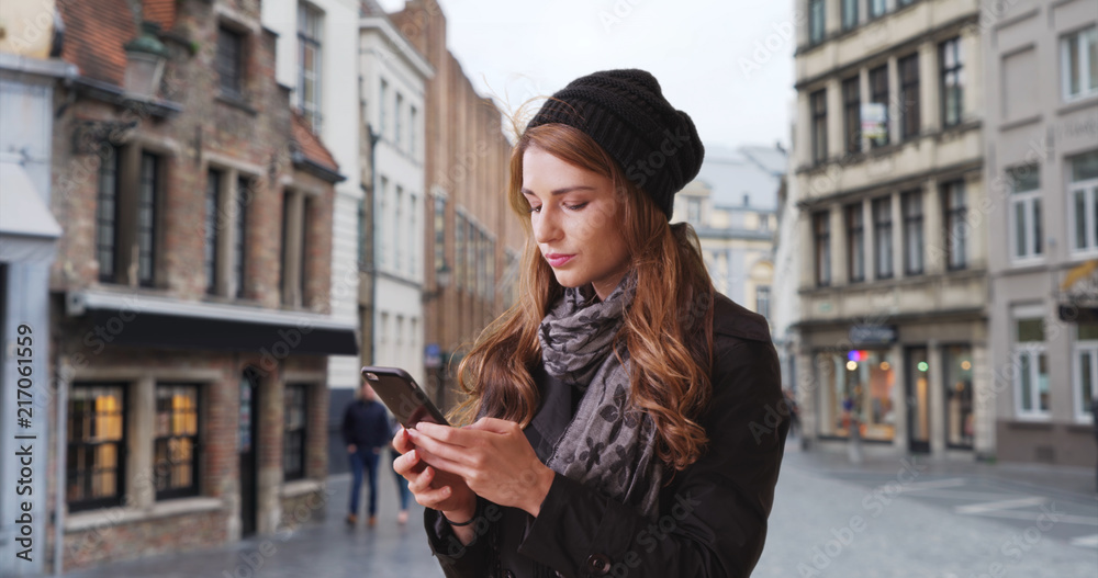Caucasian woman lost in Bruges Belgium texting friend on mobile phone Caucasian woman lost in Bruges Belgium texting friend on mobile phone