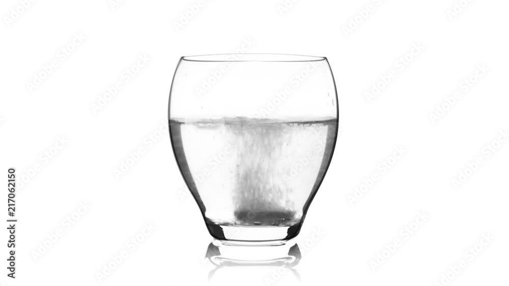 Pill falling down in glass with water