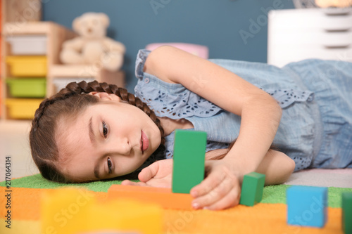 Картината върху платно Little autistic girl playing with cubes at home