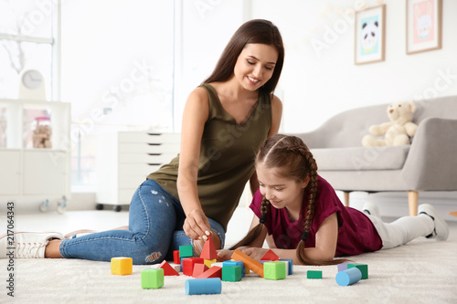 Young woman and little girl with autistic disorder playing at home