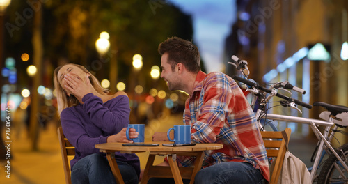 Canvas Print Smiling couple having coffee on the Champs-Elysees at night