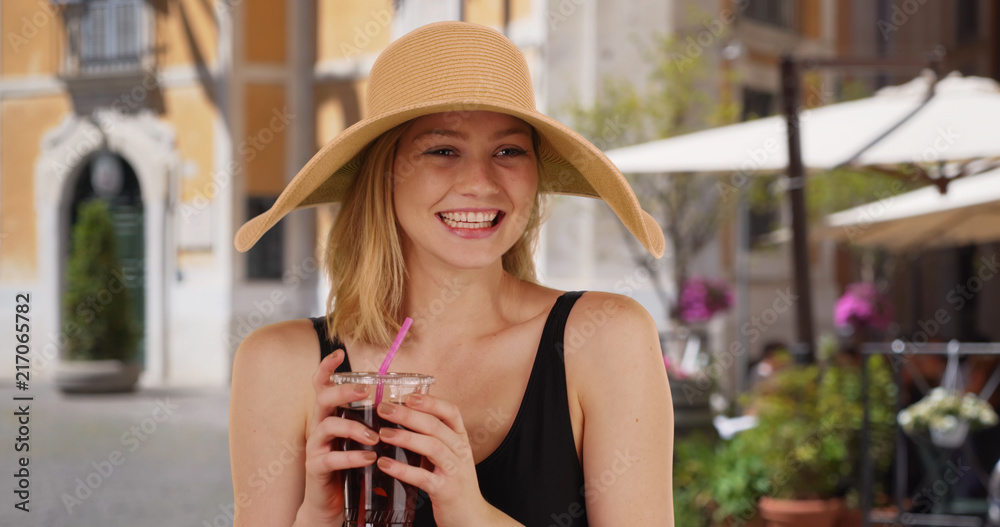 Happy and attractive blonde female drinking tea in Italy