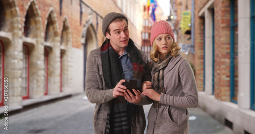 Attractive male and female using smartphone for directions on Belgian streets