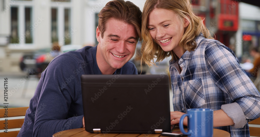 Fototapeta premium Happy Caucasian man and woman watching video on laptop laughing