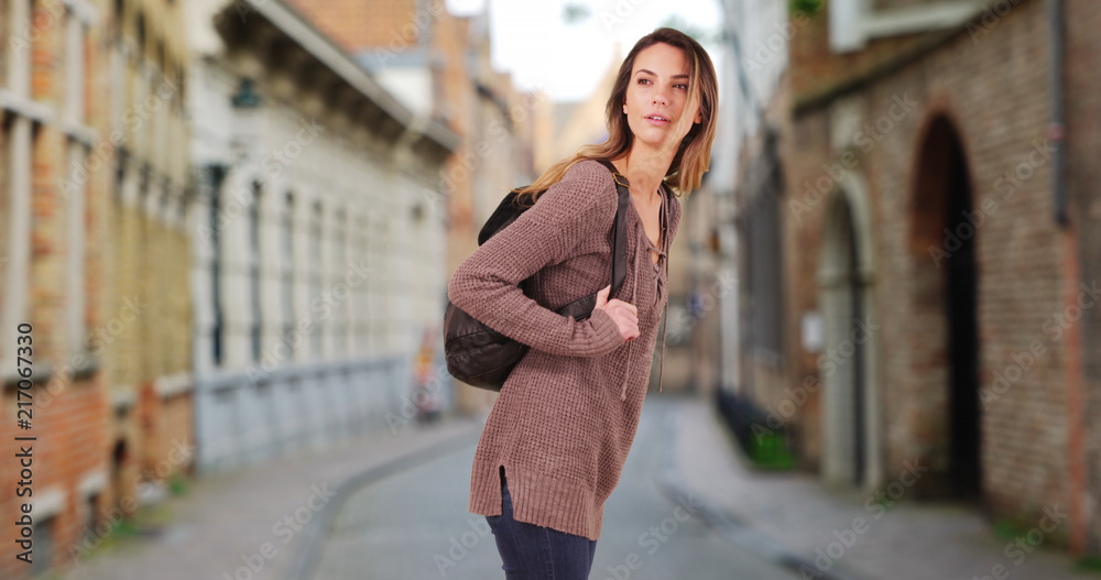 Attractive Caucasian woman wandering down small street in Bruges