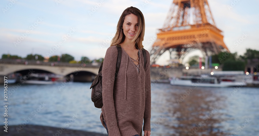 Woman by the Seine in Paris France at dusk smiling at camera