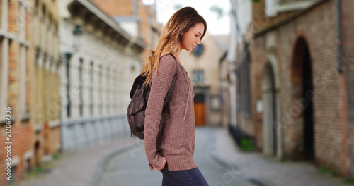 Attractive Caucasian woman wandering down small street in Bruges