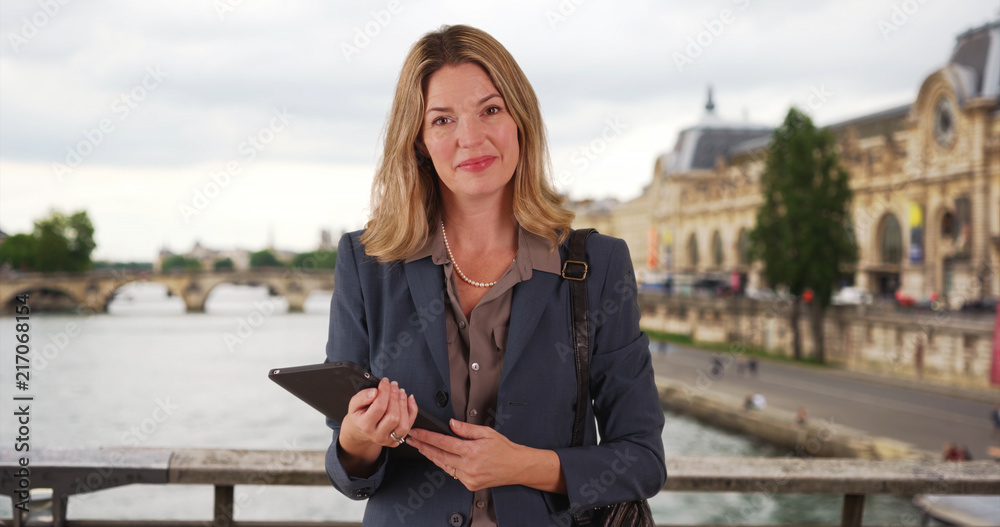 Smiling portrait of Paris businesswoman using touchpad