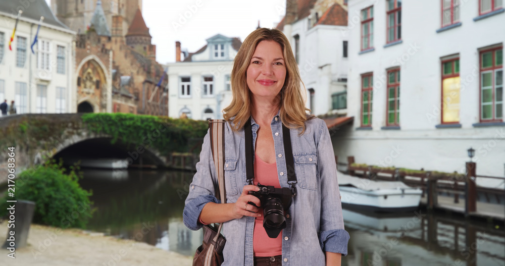 Portrait of woman tourist with her camera in Bruges