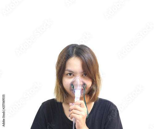 Young woman using nebulizer for asthma and respiratory diseases at home on white background