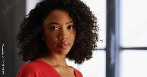 Young black lady deep in thought turning to face camera in indoor setting