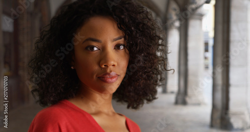 Obraz na plátně Casual African-American millennial girl with somber expression outside in stone