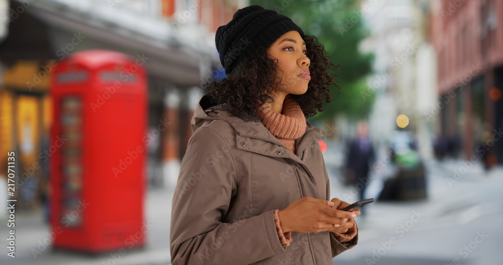 Fototapeta premium Tourist using mobile rideshare app while on holiday in London