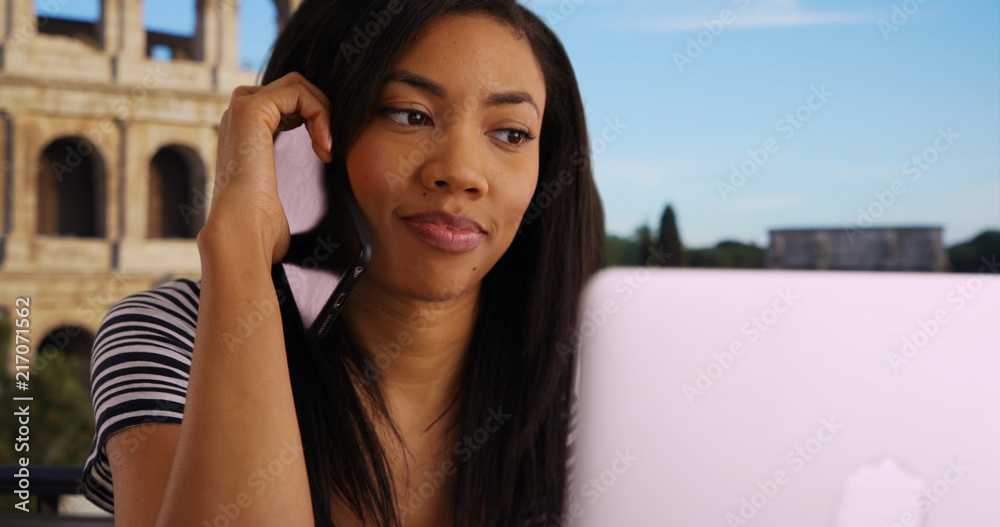 Successful black female working on vacation in Rome making overseas phone call
