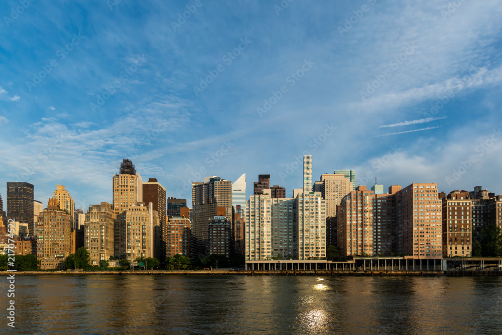 Fototapeta premium New York City / USA - JUL 31 2018: Midtown Manhattan buildings, skyscrapers and apartments view from Roosevelt Island in the early morning