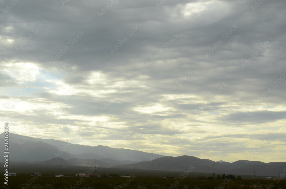 monsoon rain clouds over mountain range edging dry Mojave Desert valley landscape in Nevada, USA