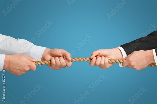 Tug war, two businessman pulling a rope