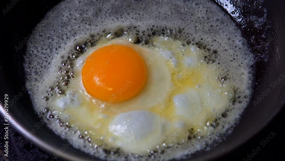 An egg being fried in butter in a pan. An egg being fried in butter in a pan.