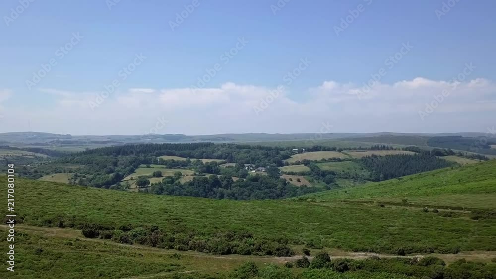 Wide shot aerial tracking backwards across the edges of Dartmoor, revealing farms and fields. Devon, England Wide shot aerial tracking backwards across the edges of Dartmoor, revealing farms and fields. Devon, England