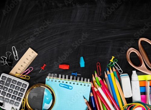 Colorful school supplies on background