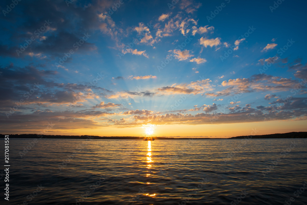 Sunset over lake with boat silhouette Sunset over lake with boat silhouette