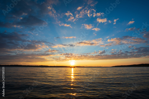 Sunset over lake with boat silhouette 