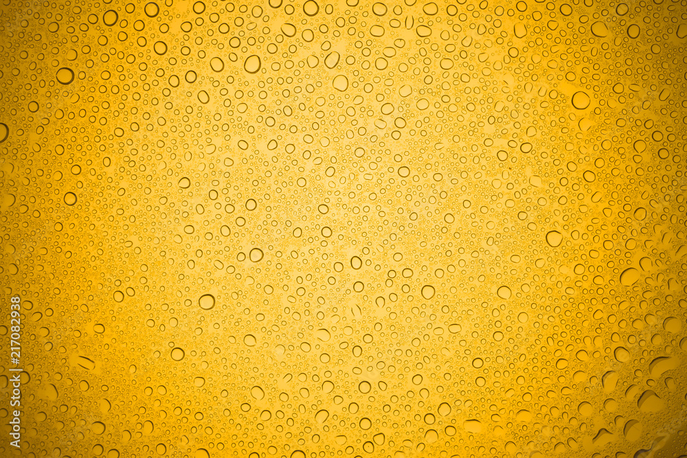 Water drops on yellow glass, Rain droplets on glass background.