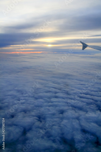 High Altitude Sunset over the Clouds from a Plane Window.