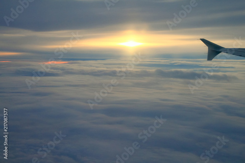 High Altitude Sunset over the Clouds from a Plane Window. © Angelina Cecchetto