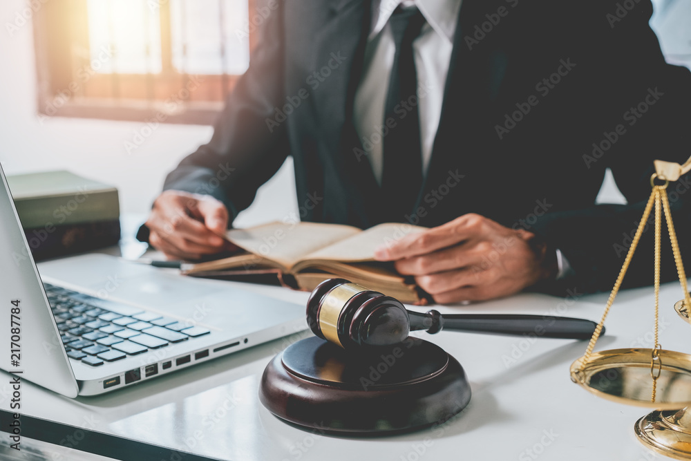 Close up gavel on white desk with Male judge reading legal books background.justice and law concept. Close up gavel on white desk with Male judge reading legal books background.justice and law concept.