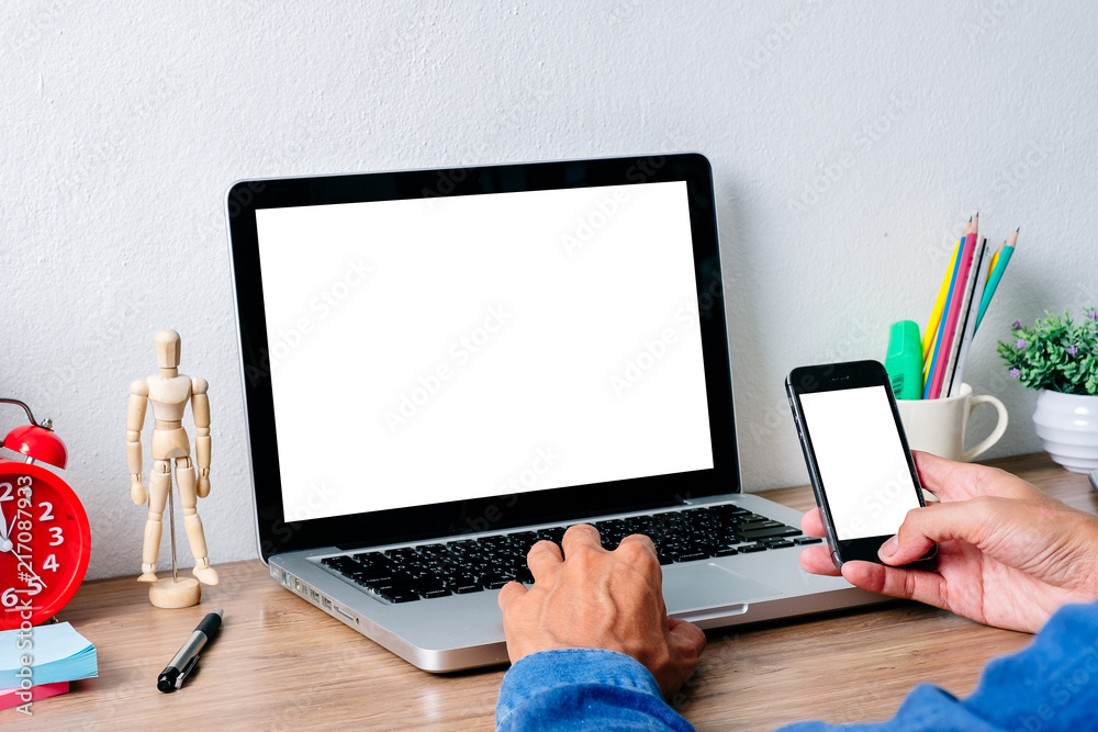 Office desk mockup concept.Mockup modern desktop with man hand using blank screen laptop computer and blank screen smart phone and a lot of things on white background. Office desk mockup concept.Mockup modern desktop with man hand using blank screen laptop computer and blank screen smart phone and a lot of things on white background.