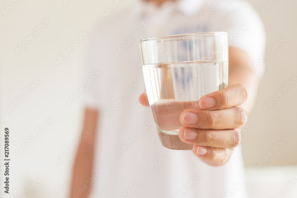 A glass of clean mineral water in man's hands. Concept of environment protection, healthy drink. A glass of clean mineral water in man's hands. Concept of environment protection, healthy drink.