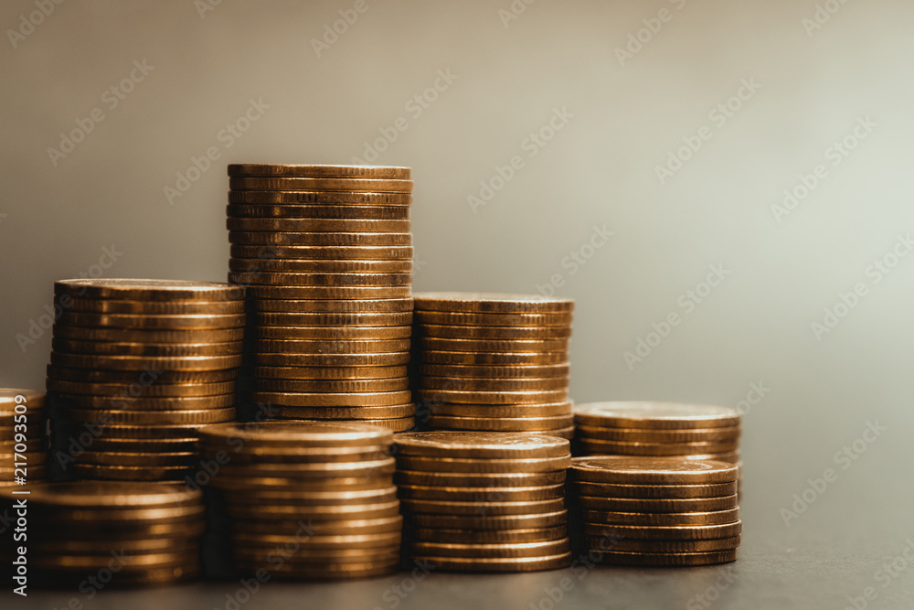 Savings, increasing columns of coins, piles of coins arranged as a graph in dark room, business banking concept. Savings, increasing columns of coins, piles of coins arranged as a graph in dark room, business banking concept.